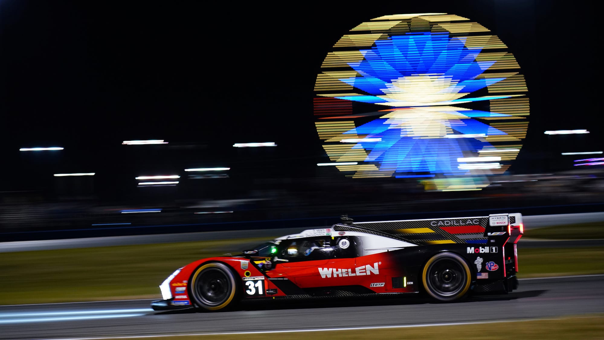 The #31 Cadillac at night with the ferris wheel in the background at Daytona International Speedway.