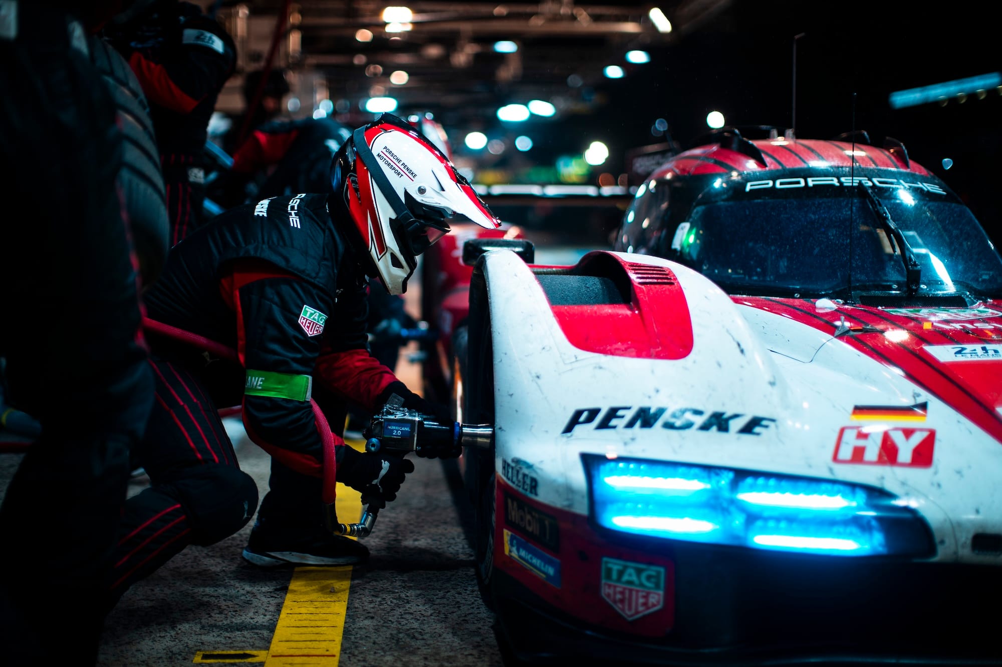 A mechanic changing a wheel on a factory Penske-run Porsche.