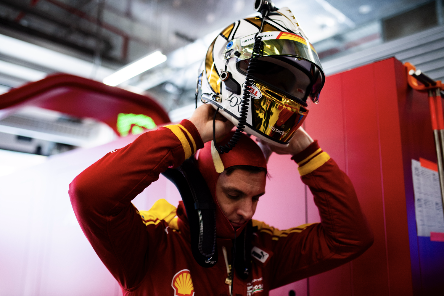 Ferrari's James Calado putting his helmet on in the pits.