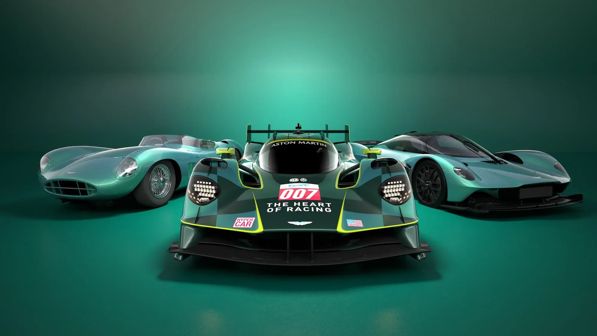 The Aston Martin Valkyrie AMR-LMH in green WEC livery, flanked by the Aston Martin DBR1 and the road car version of the Valkyrie.