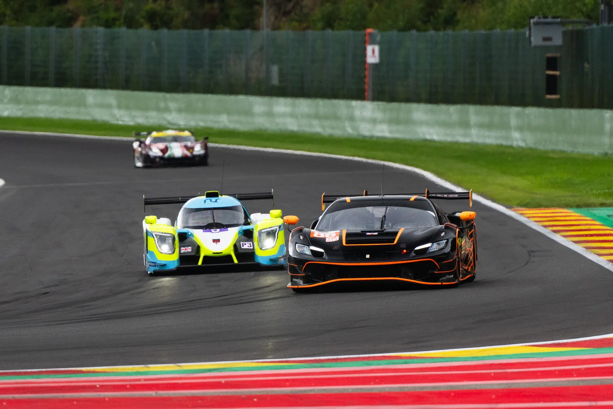 The GR Racing Ferrari 296 GT3 at Spa Franchorchamps, entering the 'bus stop' chicane, followed by a Ligier LMP3 car.